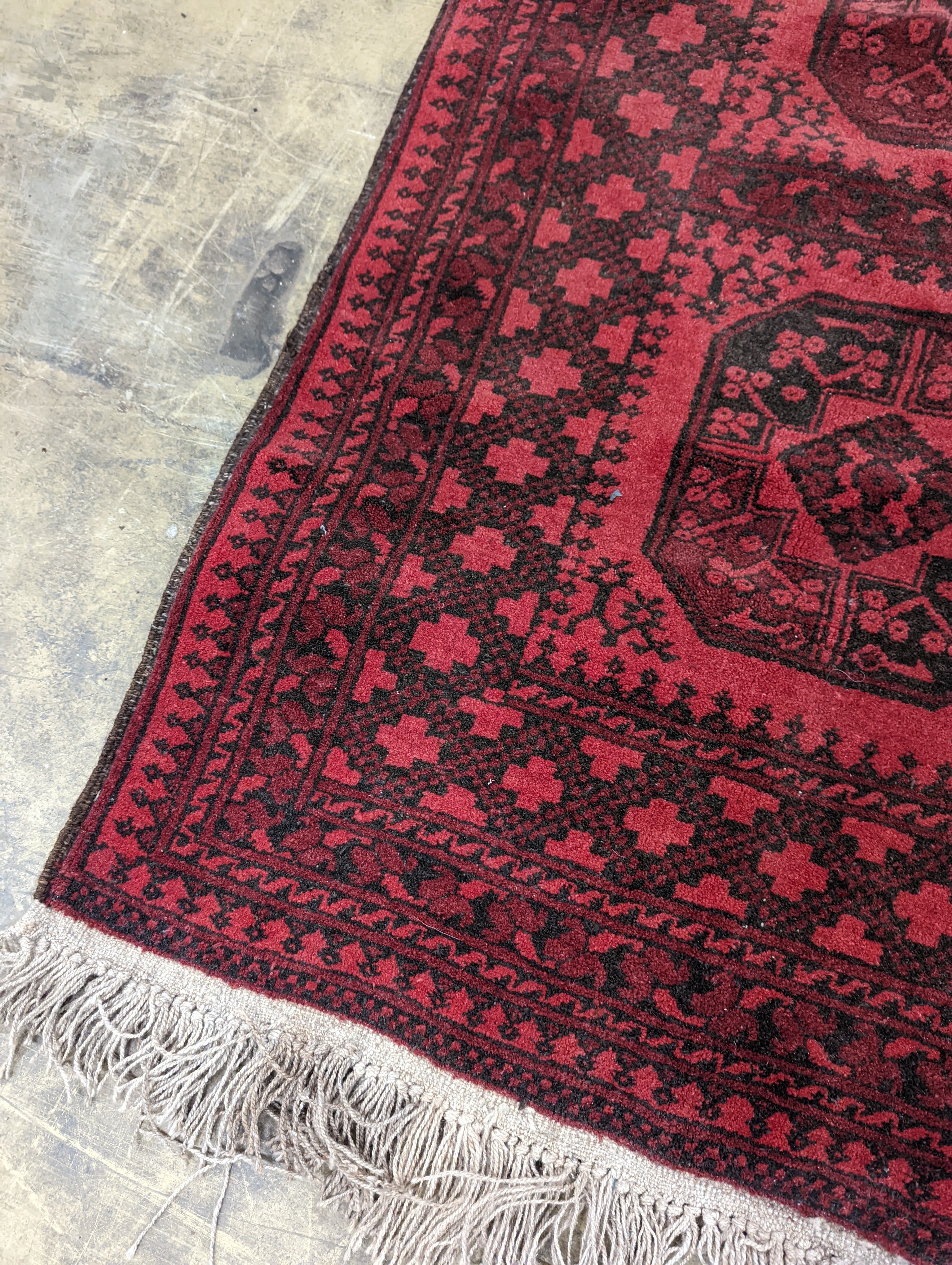 An Afghan red ground rug, 140 x 96cm